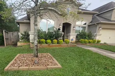Front yard with a river rock ring around a tree (photo 2 of 8)