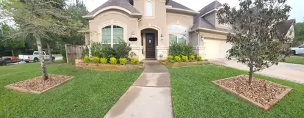 Front yard with a river rock ring around a tree (photo 4 of 8)