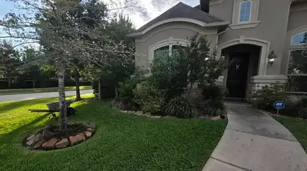 Front yard with a river rock ring around a tree (photo 7 of 8)