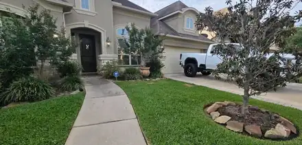 Front yard with a river rock ring around a tree (photo 8 of 8)