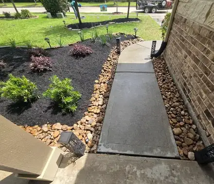 Flower bed with black mulch and a natural stone border (photo 5 of 8)