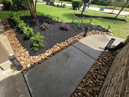 Flower bed with black mulch and a natural stone border (photo 6 of 8)