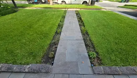 Stone walkway beside a mulched bed with a brick border (photo 4 of 8)