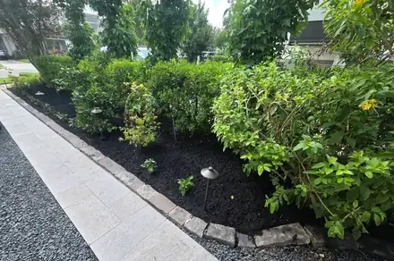 Stone walkway beside a mulched bed with a brick border (photo 5 of 8)